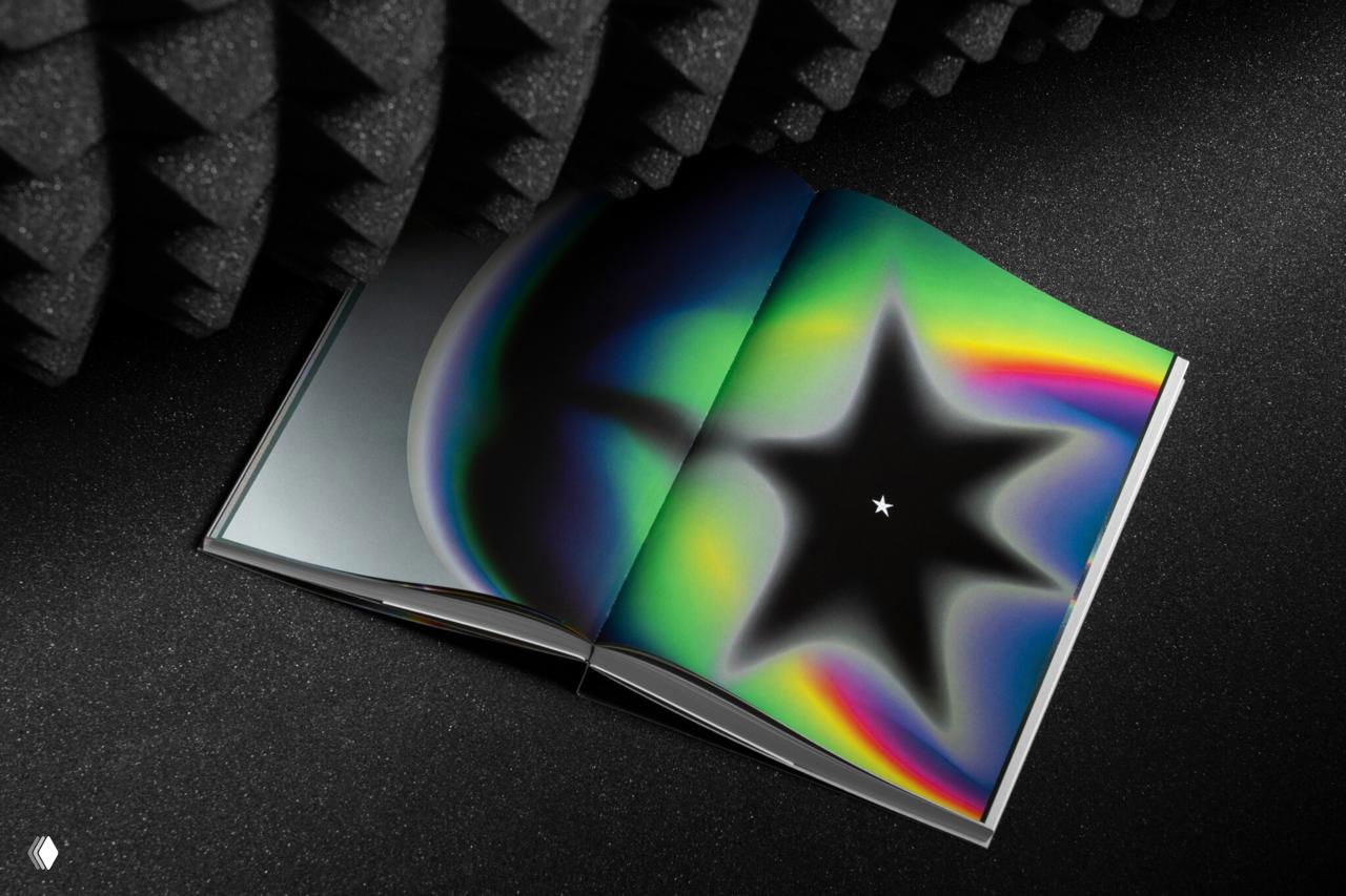 Фото разворота со звёздчатой радужной фигурой, центр разворота тёмный, вокруг — цветные ореолы и градиенты.