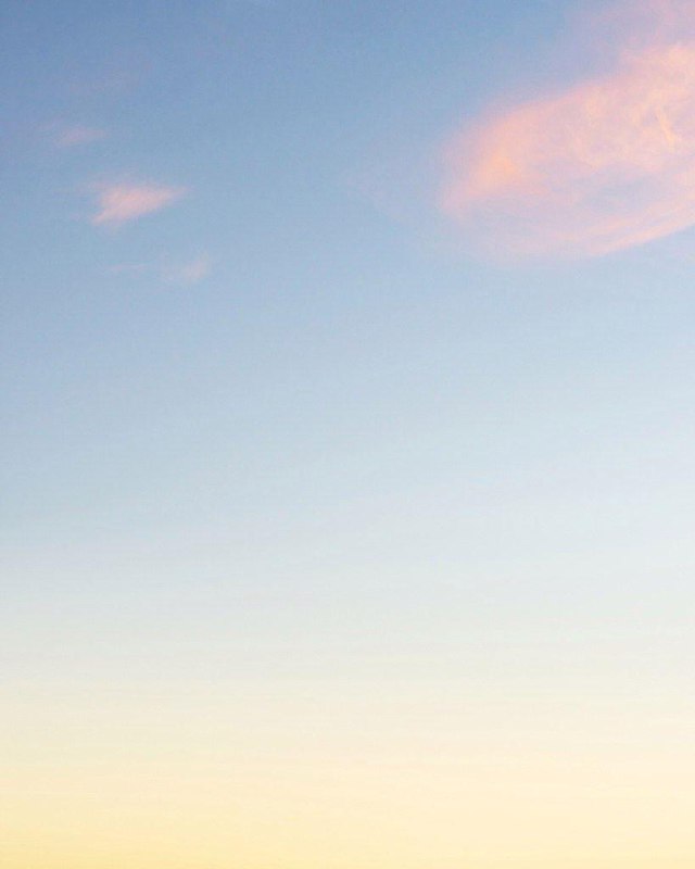 Насыщенный красно‑оранжевый градиент, переходящий в тёплые тона; кадр подчёркивает геометрию и цветовые блоки в небе.