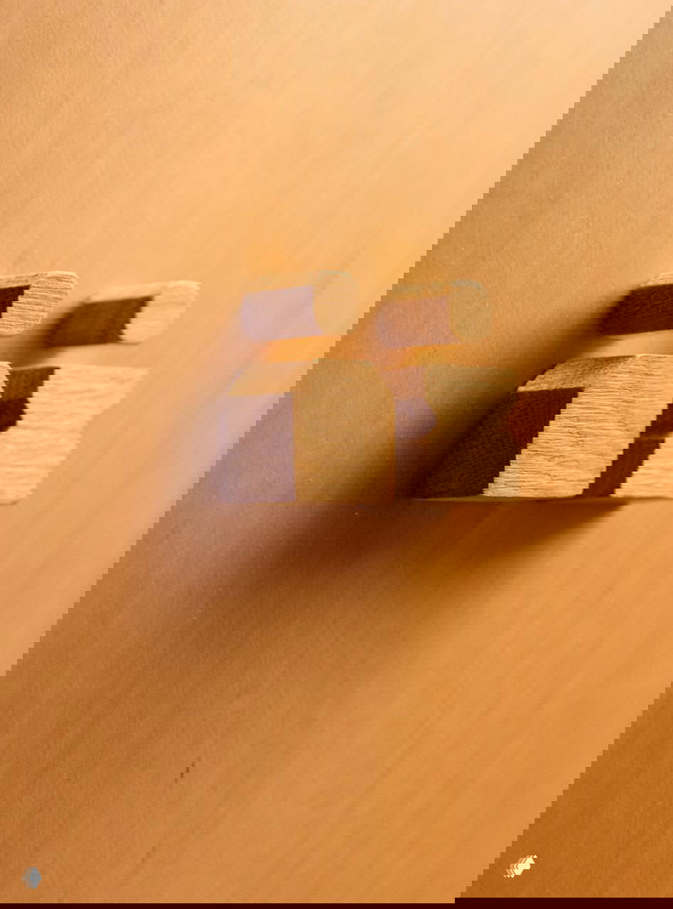 Крупный план деревянных декоративных ручек и точечных деталей на светлой панели — фрагмент интерьера и брендинга, подчёркивающий текстуру и тактильность материалов