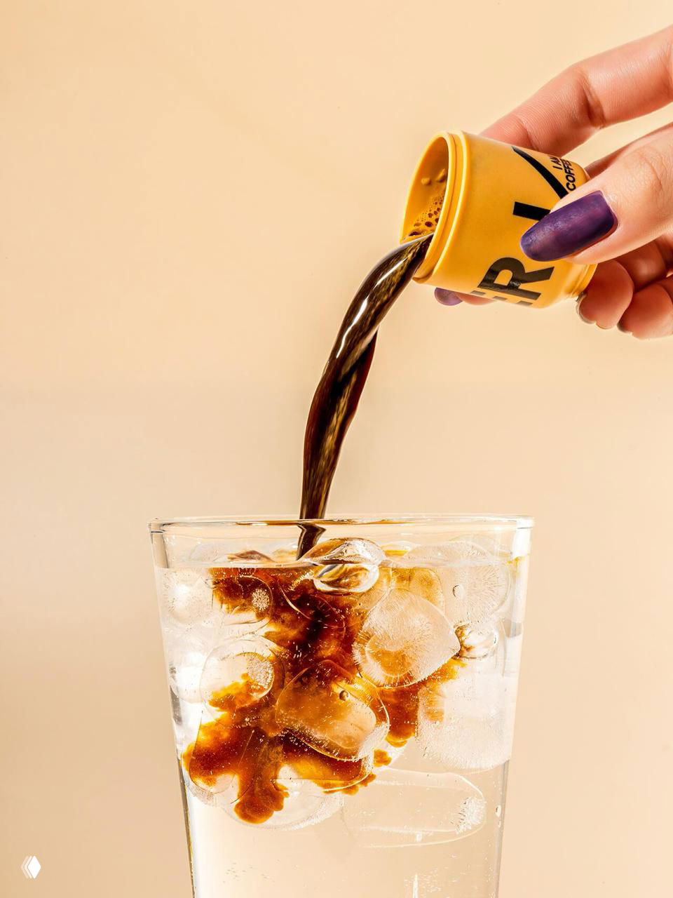 Рука наливает эспрессо из мини-баночки David’s Choice в стакан со льдом на нейтральном фоне, чистое освещение, подчёркнутый контраст и текстура льда для визуального эффекта.