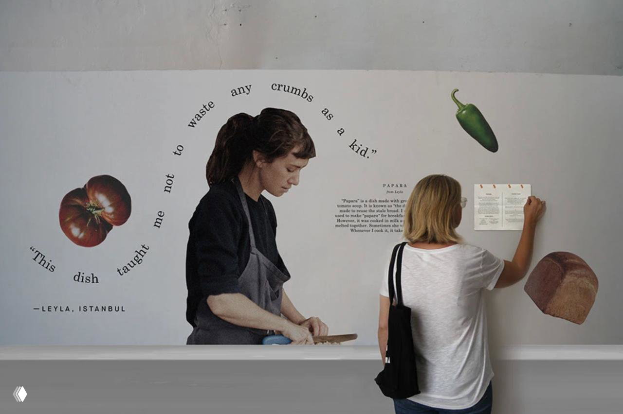 Стенд с изображением повара и коллажами овощей и хлеба; текст по дуге обрамляет изображение, показывая принцип типографики в айдентике Crumbs.