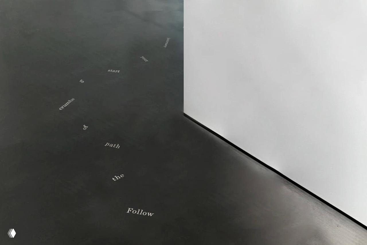 Крупный план тёмного пола галереи с разбросанными типографскими словами, минималистская композиция и игра пустых пространств в фирменном стиле.