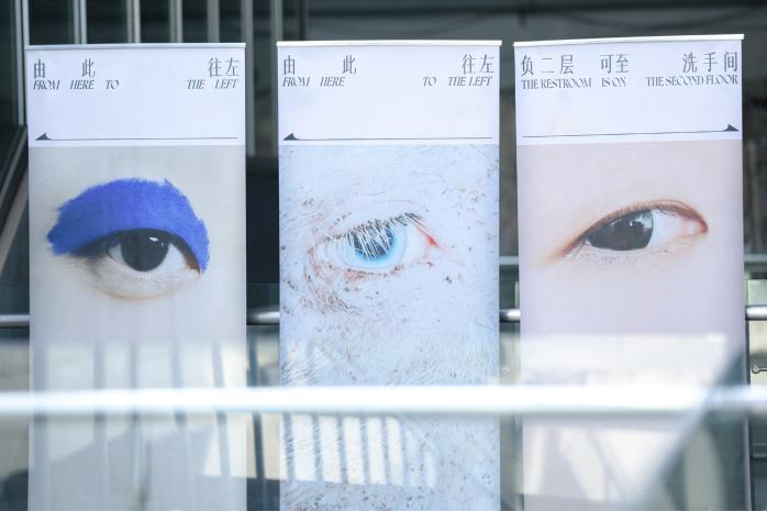 Три вертикальных баннера в интерьере с крупными изображениями глаз: художественное решение айдентики Design Inter-Vision.