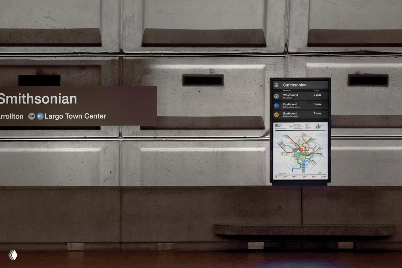 Дисплей-стенд на платформе Smithsonian с цифровой картой и блоком расписания — экран встроен в бетонную облицовку станции.