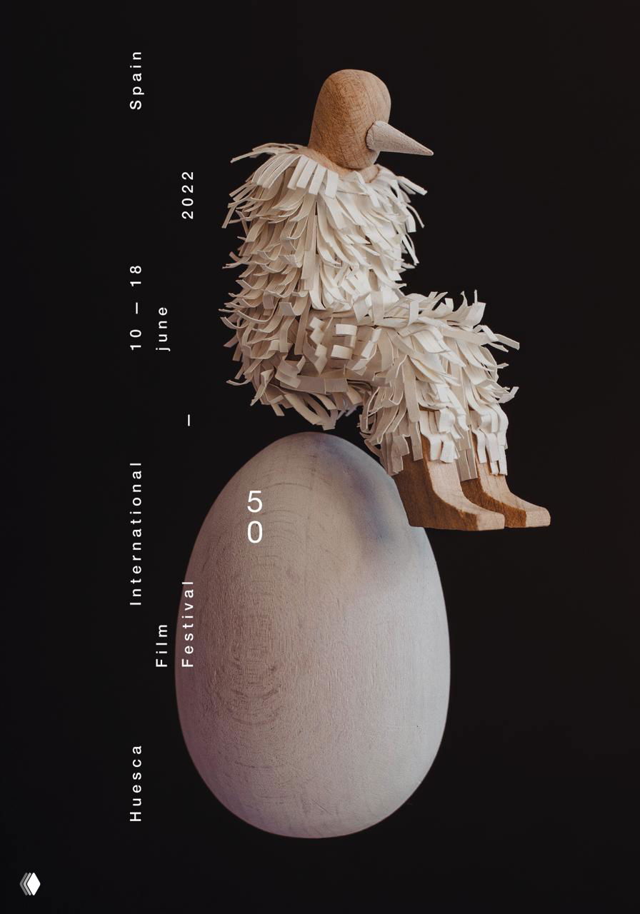 Плакат Isidro Ferrer: деревянная сидящая птица с текстурной бахромой, композиция на тёмном фоне и минимальная вертикальная типографика festival.