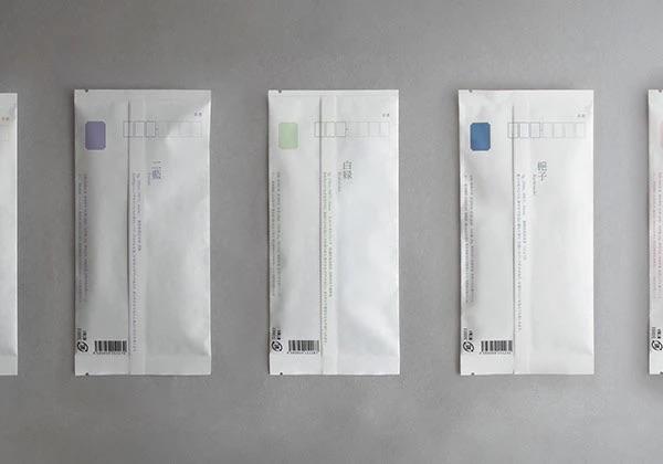 Несколько узких пакетов Kaguwa в ряд, вид сзади: штрих-код и техническая информация на белом минимальном фоне