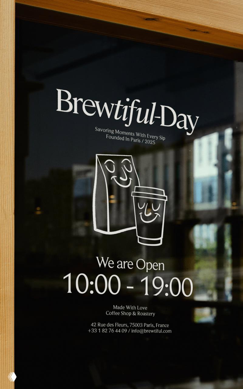 Оформление витрины кофейни Brewtiful-Day: белая графика с логотипом и маскотами на стекле, указаны часы работы и контакты.