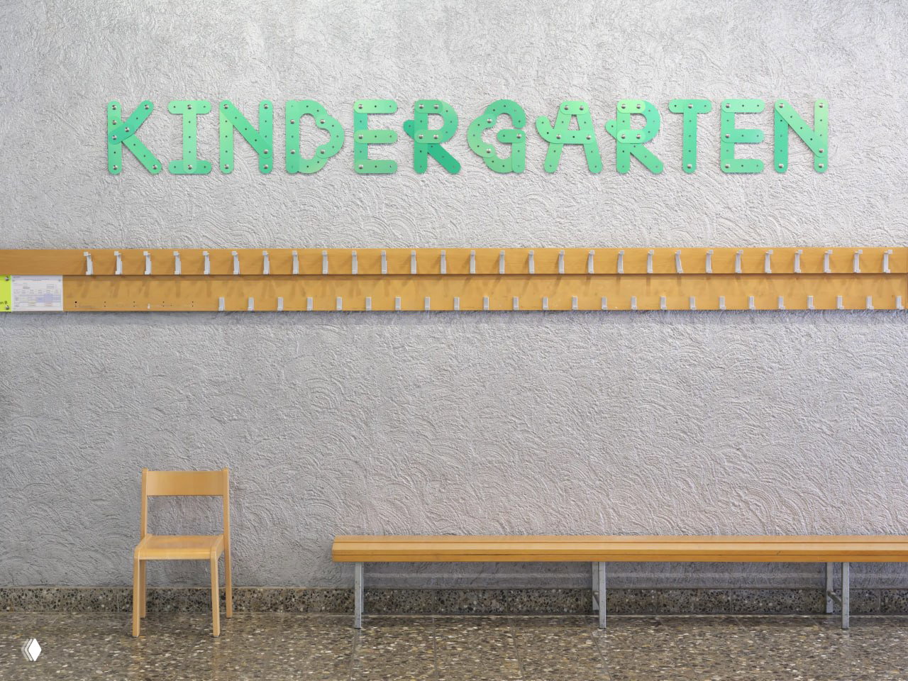 Интерьерная фотография с зелёной надписью «KINDERGARTEN» на фактурной стене, деревянная скамья и вешалки — дружелюбная навигация для детского пространства.