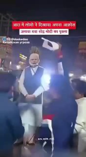 Уличный протест в Индии: толпа протестующих поджигает портрет премьера на фоне людей с плакатами и эмоциональной сценой.