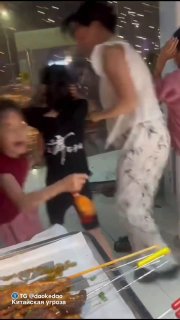 Люди в помещении возле стола с шампурами и блюдами, один человек в пижаме поднимается — кадр из видео во время тайфуна.