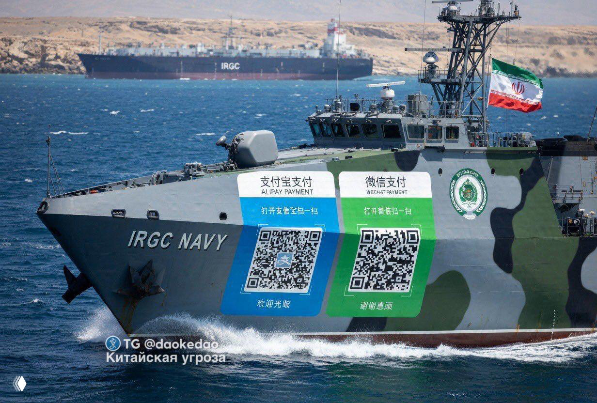 Катер ВМС IRGC в Ормузском проливе с нанесёнными крупными QR‑кодами платёжных систем Alipay и WeChat на борту; на фоне виден танкер и иранский флаг.