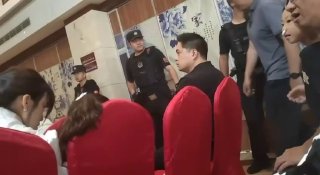 Полицейские в форме в зале с красными креслами во время рейда и задержания участников собрания домашней церкви Китая.