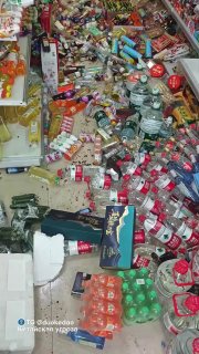 Разбросанные в магазине бутылки, упаковки и коробки — кадр с беспорядком на полу, указывающий на разрушения после землетрясения.