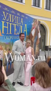 Данила Якушев и супруга Кристина стоят у баннера «Улица Ангела» на открытии в Ярославле; рядом посетители и логотип Woman.ru