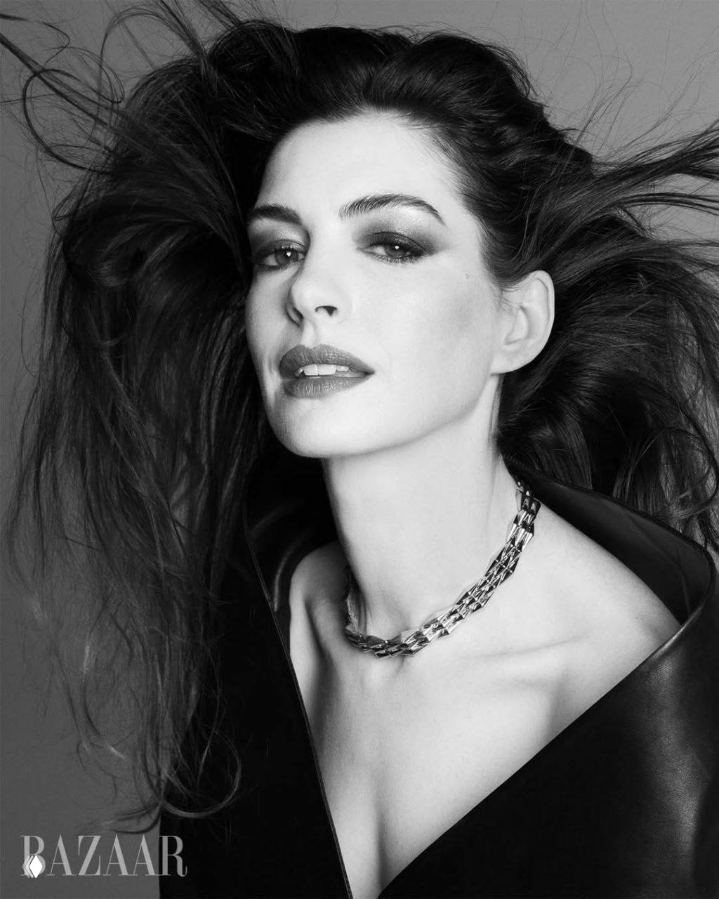 Чёрно-белый портрет женщины с развевающимися волосами и украшением на шее — элегантный модный кадр в студии.