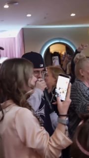 Гости вечера снимают выступление на смартфоны; кадр показывает толпу и атмосферу концерта в помещении праздника