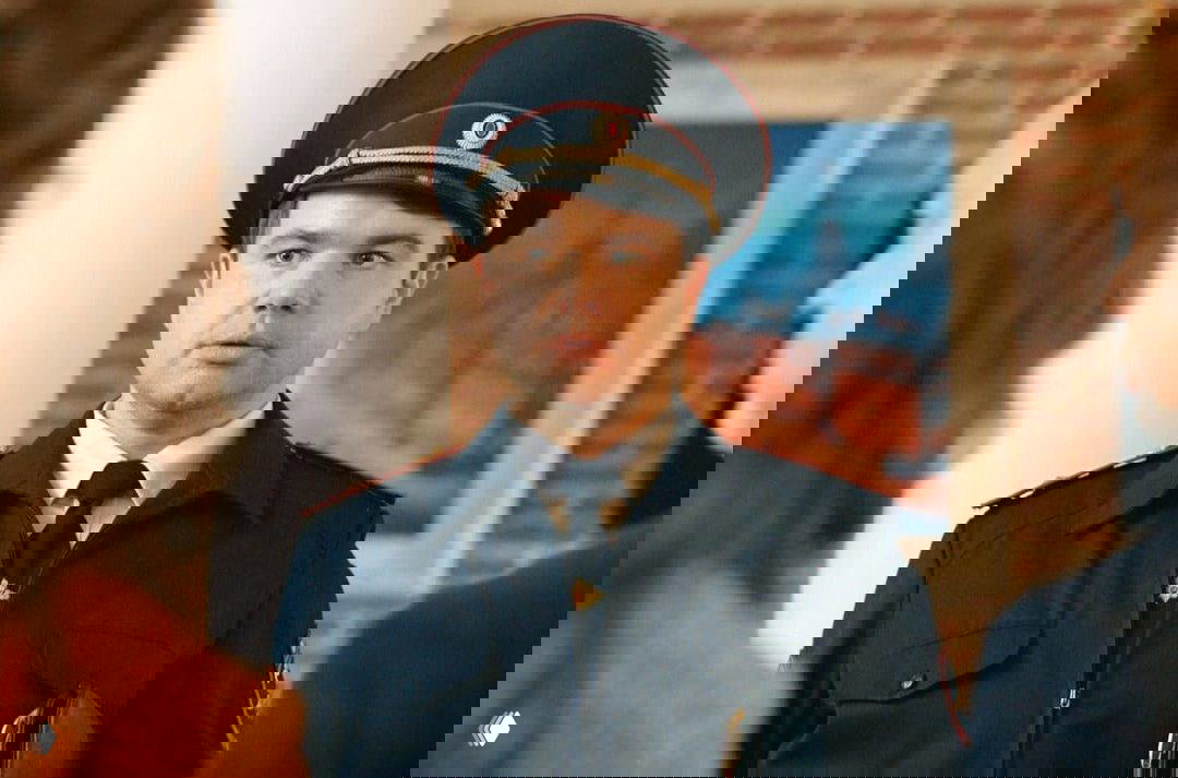 Михаил Казаков в полицейской форме (роль Полежайкина) в кадре из сериала «Папины дочки», портретная сцена в интерьере, персонаж обращён вперёд