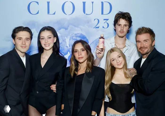 Дэвид Бекхэм рядом с членами семьи и гостями на презентации бренда — группа людей перед баннером с надписью CLOUD.