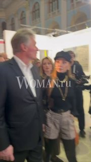 Дмитрий Песков и Татьяна Навка на открытии ярмарки «Арт Россия» в зале с выставочными стендами; момент среди посетителей и экспозиций