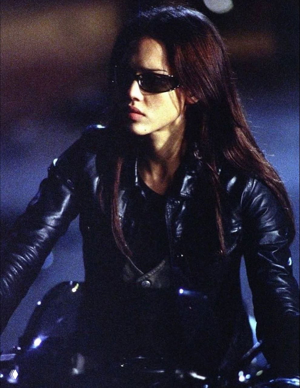 Джессика Альба в профильном кадре на мотоцикле в темной кожаной одежде — напряженная ночная сцена из телесериала.