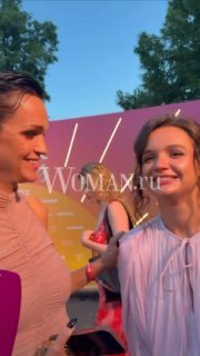 Певица улыбается во время мероприятия Blogger Party Marie Claire: пол-оборота, задник с логотипом Woman.ru и микрофон Woman.ru в кадре.