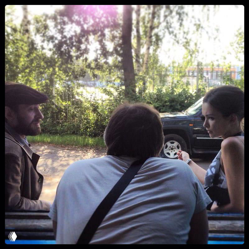 На площадке: Паулина Андреева беседует с членами съёмочной группы у машины в тёплый день, кадр показывает рабочую атмосферу съёмок.