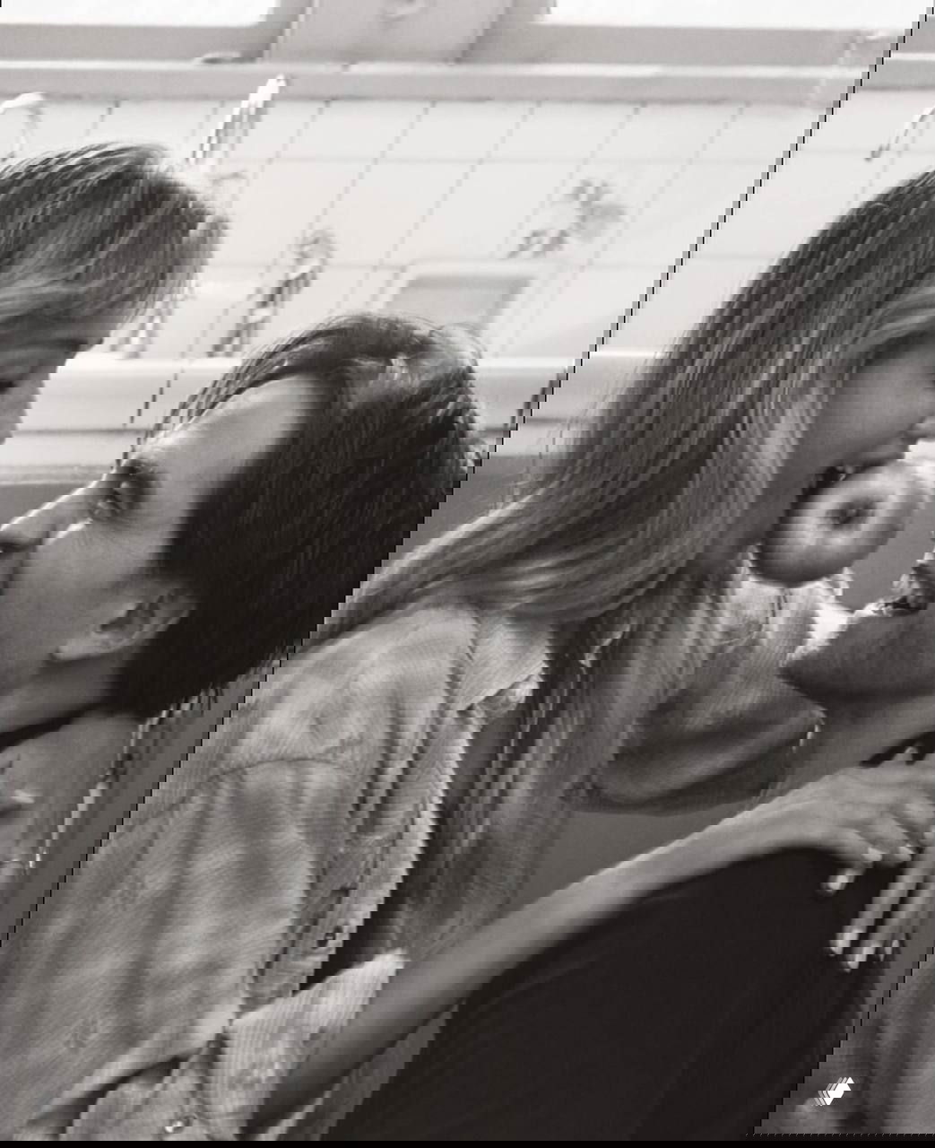 Дженнифер Лоуренс держит яблоко между зубами, Роберт Паттинсон улыбается — чёрно-белый момент из фотосессии для V Magazine.