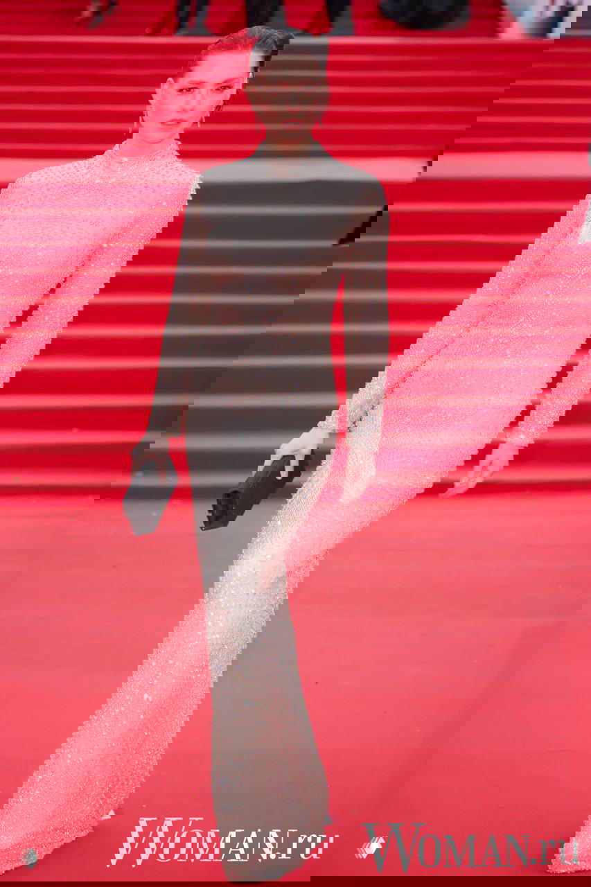 Женщина в блестящем облегающем платье с клатчем на красной дорожке ММКФ, портретный кадр в полный рост и вниманием к деталям.