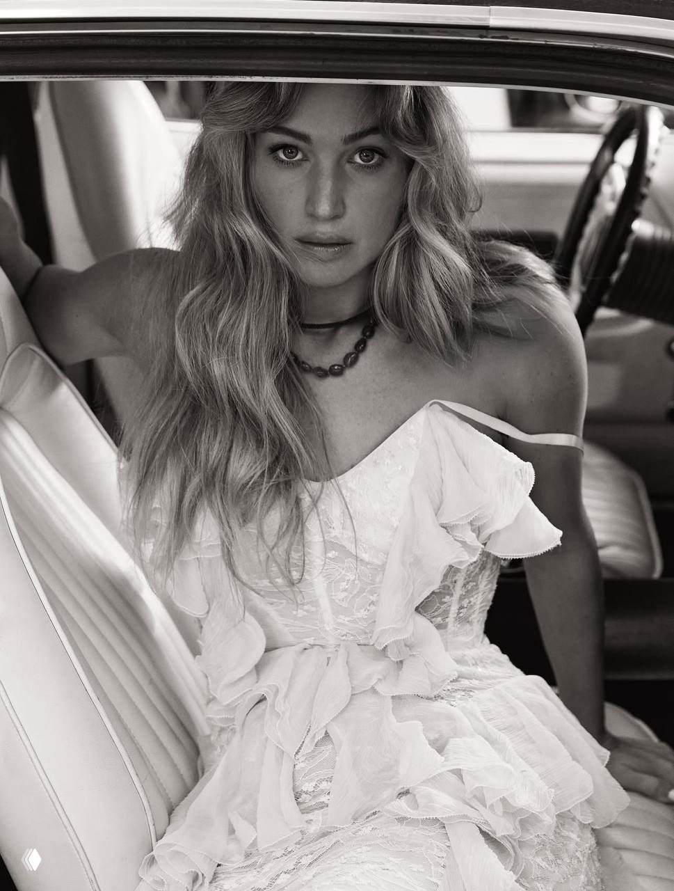 Дженнифер Лоуренс в романтичном платье на переднем сиденье автомобиля — чёрно-белый портрет из серии снимков для журнала.