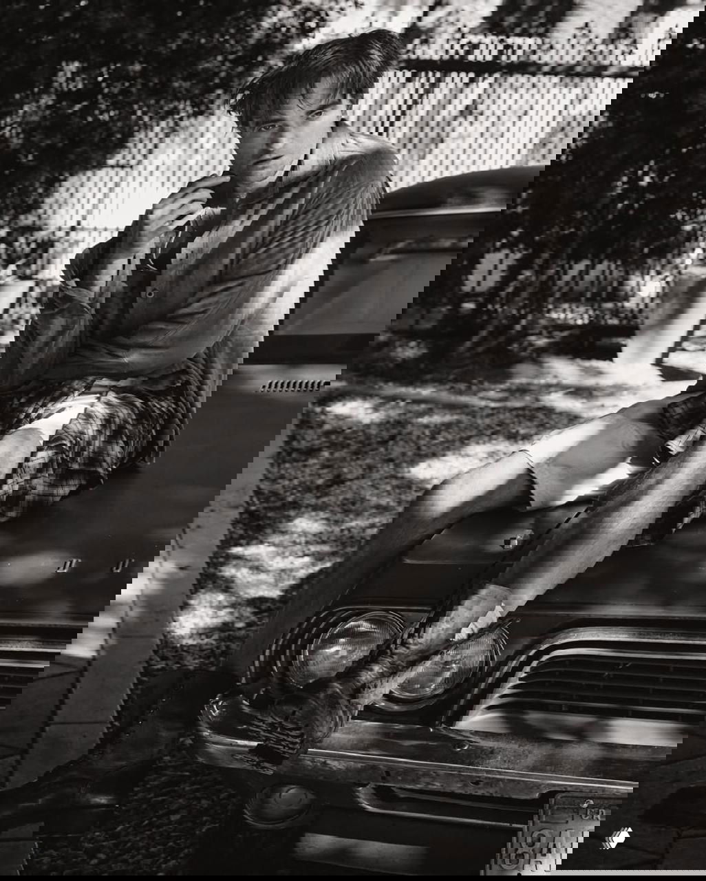 Роберт Паттинсон сидит на капоте старого автомобиля в чёрно-белом кадре — портретный снимок для V Magazine, атмосферный и задумчивый.