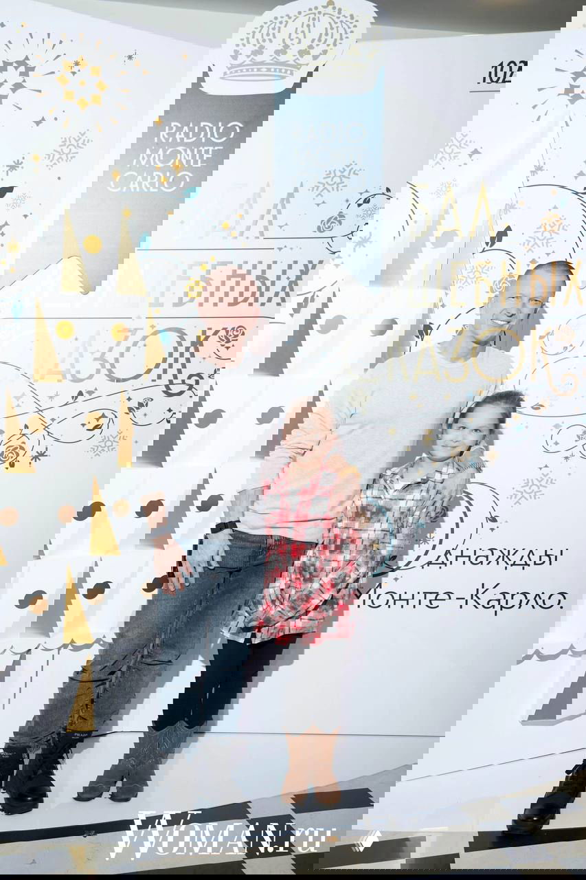 Отец присёл рядом с дочерью на полу у фотозоны бала «Волшебных сказок», на заднем плане праздничная ёлочная инсталляция Radio Monte Carlo.