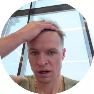 Крупный план Дмитрия Тарасова в спортзале: лицо и верхняя часть туловища, рука на голове, видны окна зала на заднем плане.