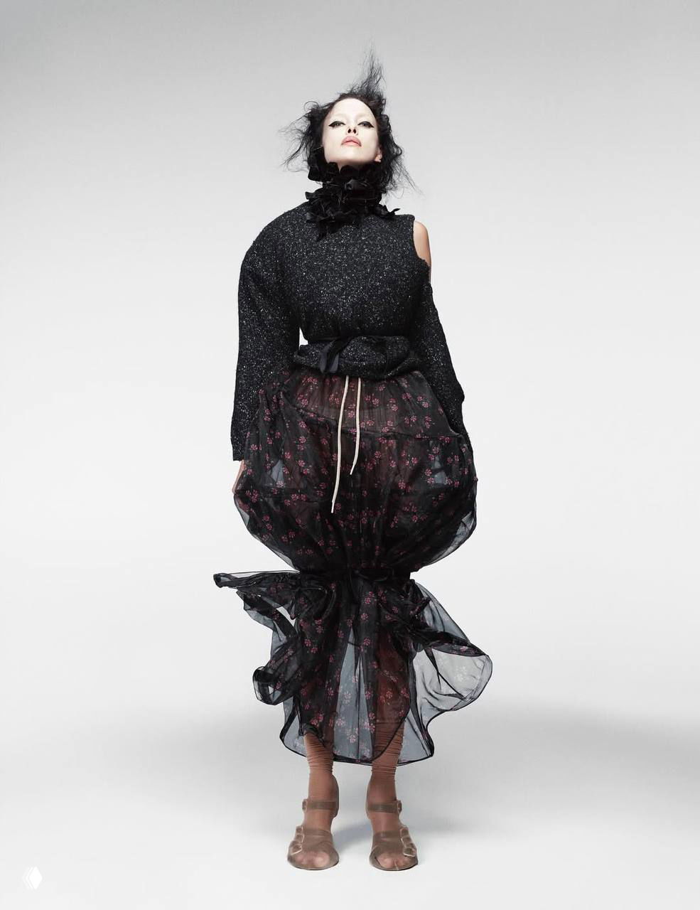 Ирина Шейк в драматичном наряде: высокая посадка одежды, воздушная юбка и строгое студийное освещение — модный образ из фотосессии для журнала.