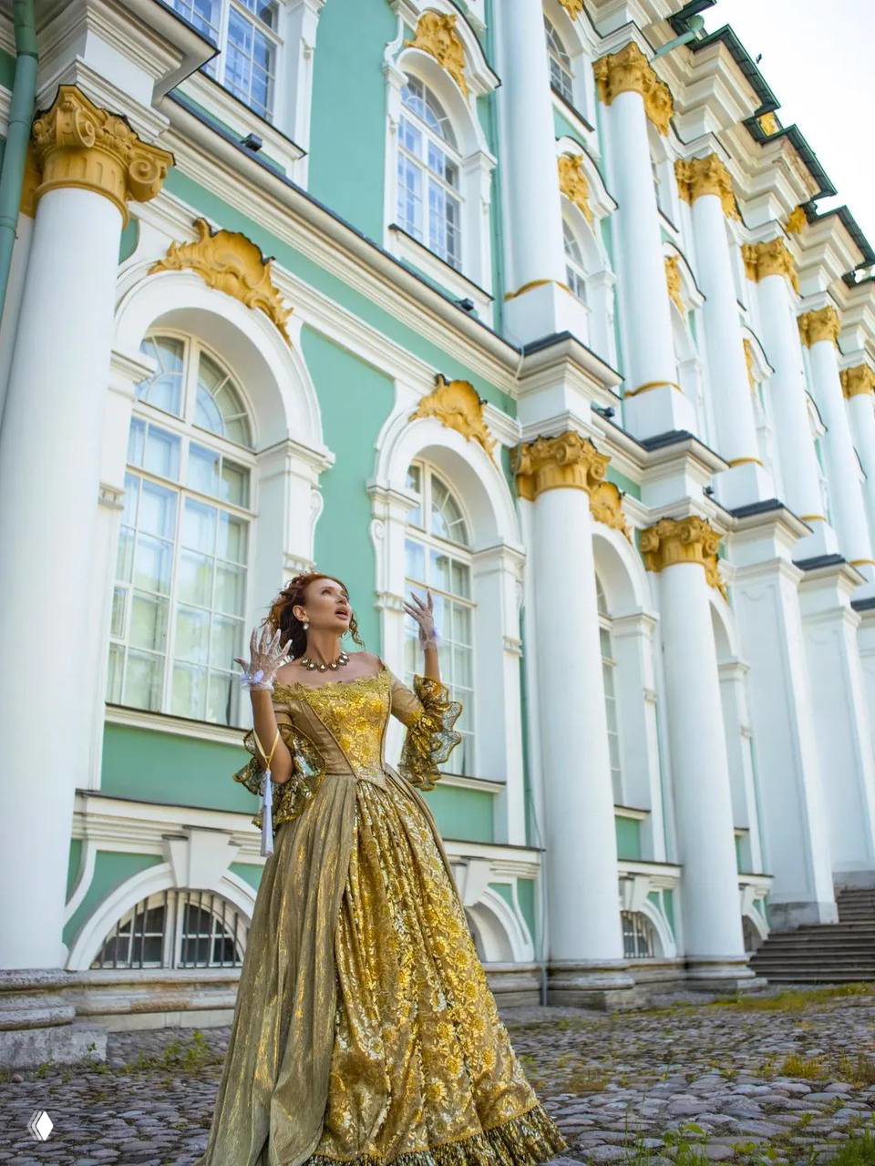 Эвелина Бледанс в бальном платье на фоне колонн и больших окон дворца, позирует в полный рост — репортажный кадр.