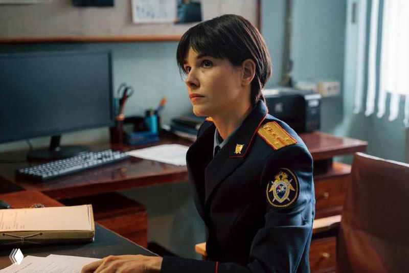 Искажённый кадр с близким планом актрисы на съёмочной площадке: видны артефакты, свет и реквизит через цифровые помехи.