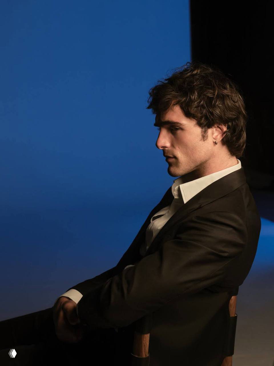 Силуэт сидящего мужчины на фоне синего экрана — контрастный кадр рекламной съёмки, акцент на силуэте и позе.