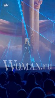 Сцена фестиваля с лазерными эффектами и проекцией певицы, кадр из номера на «Песня года 2025», вид с публики