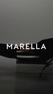 Крупный кадр с логотипом Marella на минималистичном фоне: тёмные формы и светлая надпись, стилизованный рекламный сюжет.