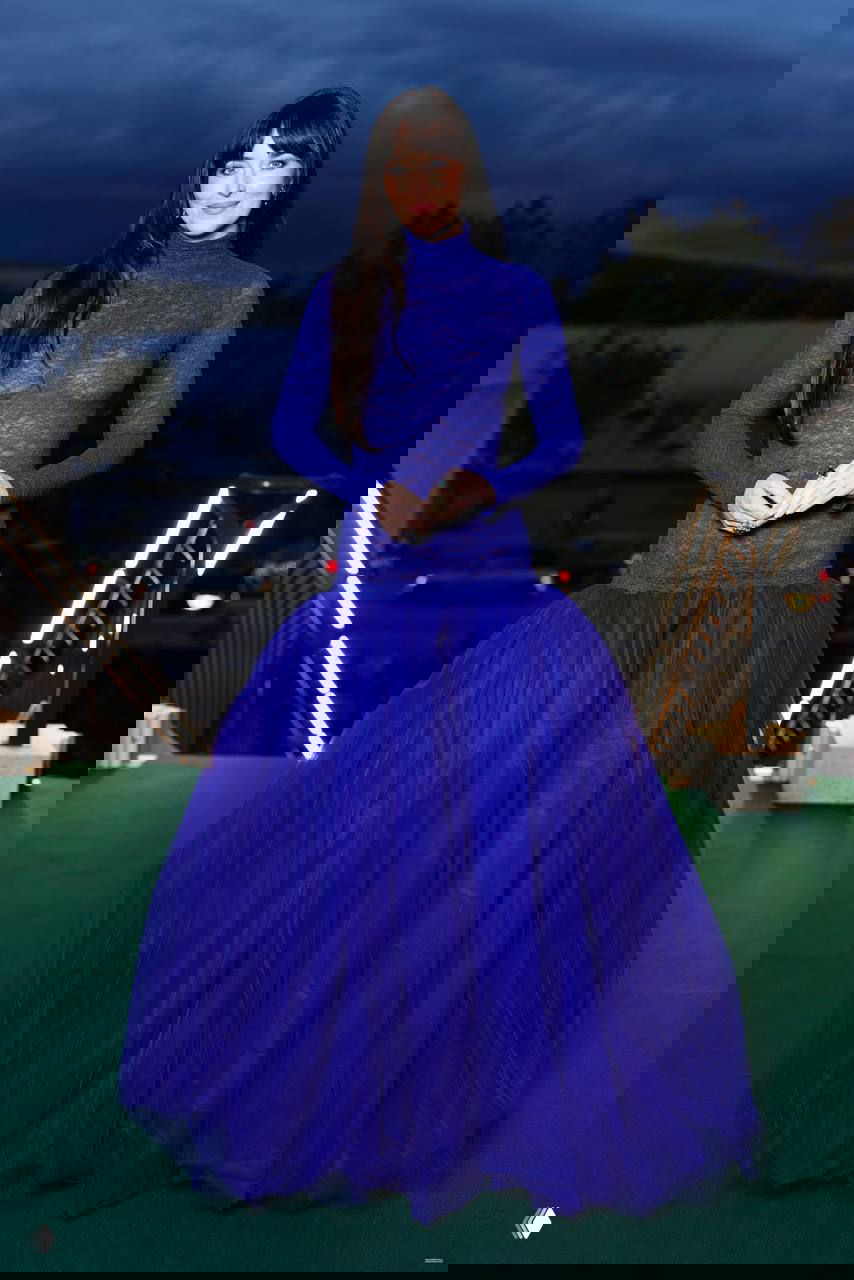 Женщина в ярком синем платье с объёмной юбкой и полупрозрачным верхом; эффектный контраст фактур и насыщенный цвет на вечернем приёме.