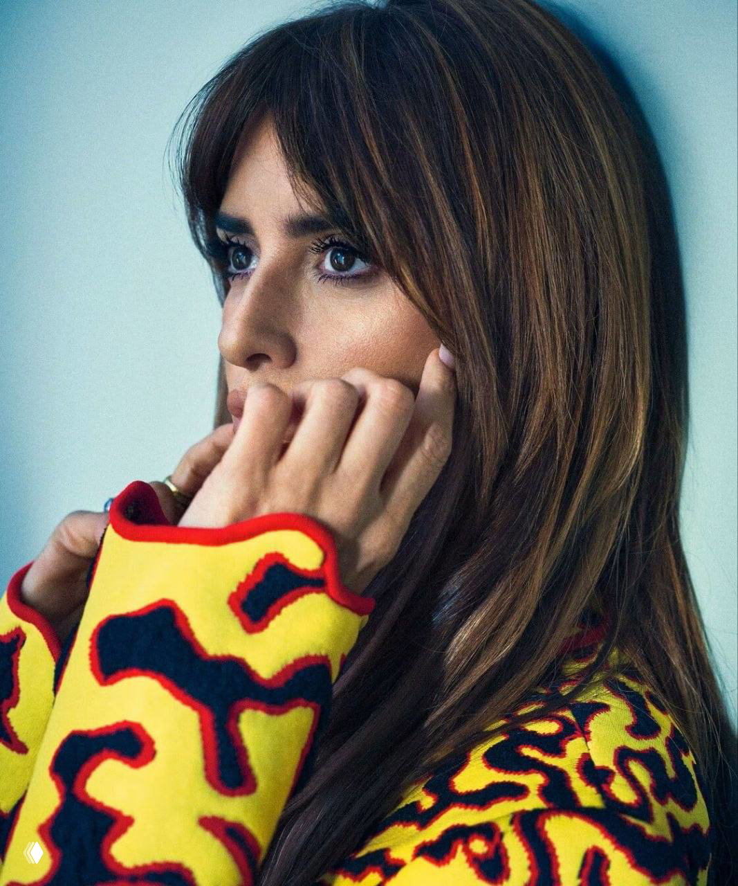 Крупный план лица: натуральный макияж, длинные волосы и деталь одежды с ярким вязаным узором — акцент на портретной съёмке для модного журнала.