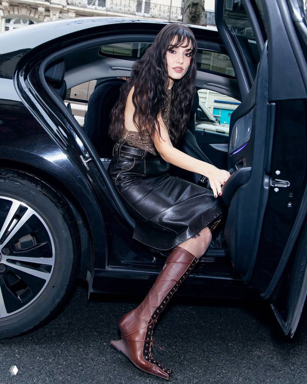 Актриса выходит из машины в дерзком образе: кожаная юбка, коричневые ботфорты и вечерний макияж — фото с модного мероприятия в Москве.