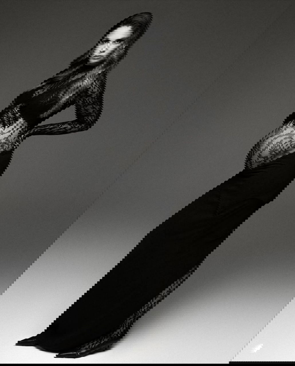 Черно-белый кадр Агаты Муцениеце в профиль: кружевной топ и длинная юбка, подчеркнутый профиль беременного живота, строгая студийная стилизация