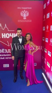 Вячеслав Макаров и Елена Север на красной дорожке концерта «Звезды Русского Радио» в Санкт‑Петербурге; фон с логотипами фестиваля и Woman.ru.