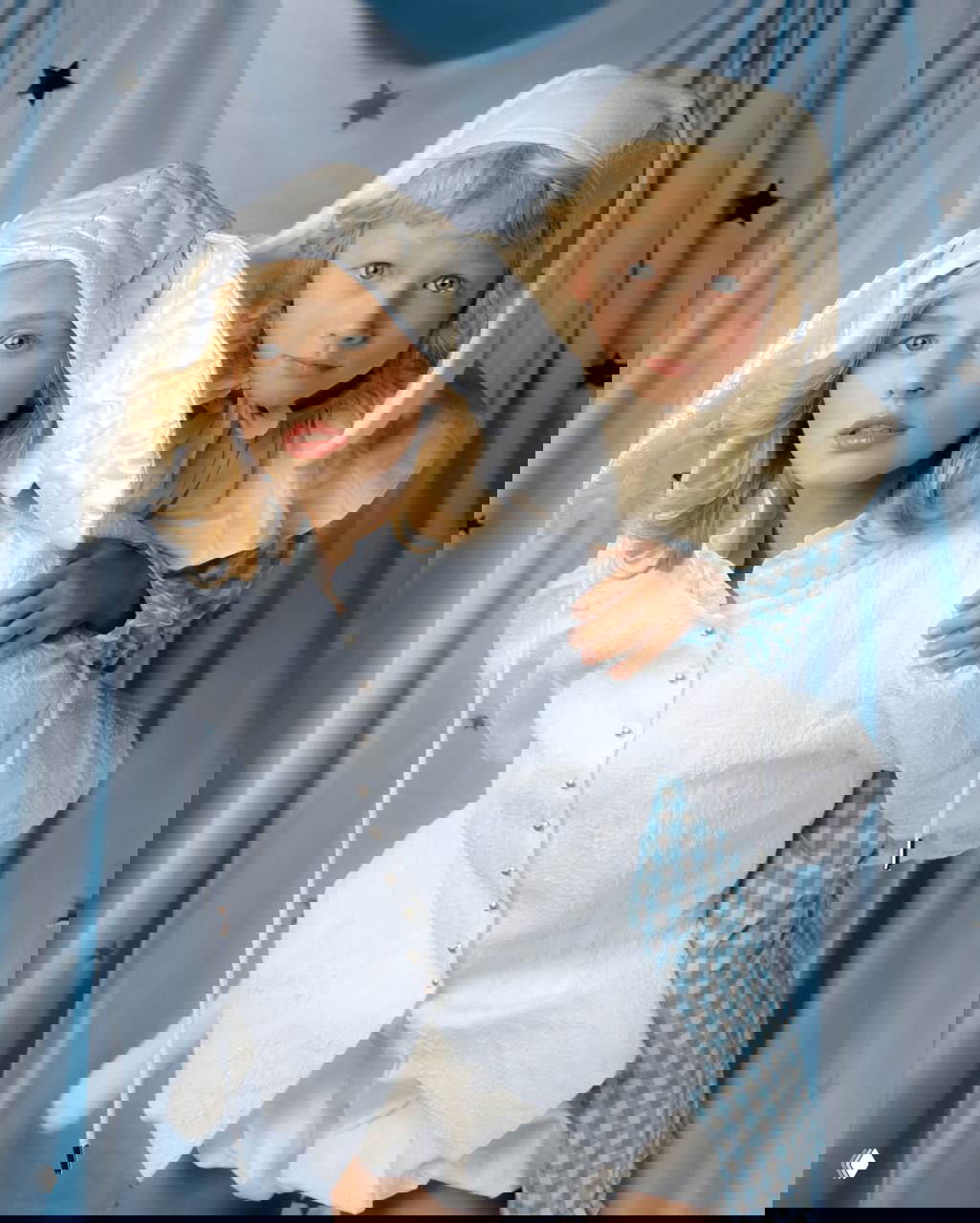 Портретная студийная фотография: молодая женщина и мальчик в светлых нарядах и милых шапочках на нейтральном фоне с декоративными звёздами