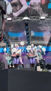 Коллективный кадр с выступления на сцене VK FEST: Катя IOWA и танцоры в ярких нарядах, мощное сценическое освещение и проекция на заднике.