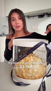 Женщина раскрывает подарочную коробку с куличом, внутри виден кулич со сусальным золотом и декоративная лента, указана цена 30 000 ₽.