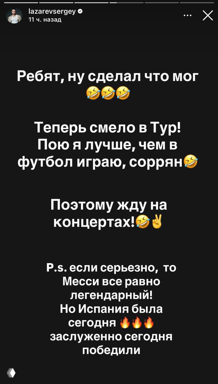 Мужчина в синей футболке улыбается, опершись на перила трибуны; видна татуировка на предплечье и солнечный день.