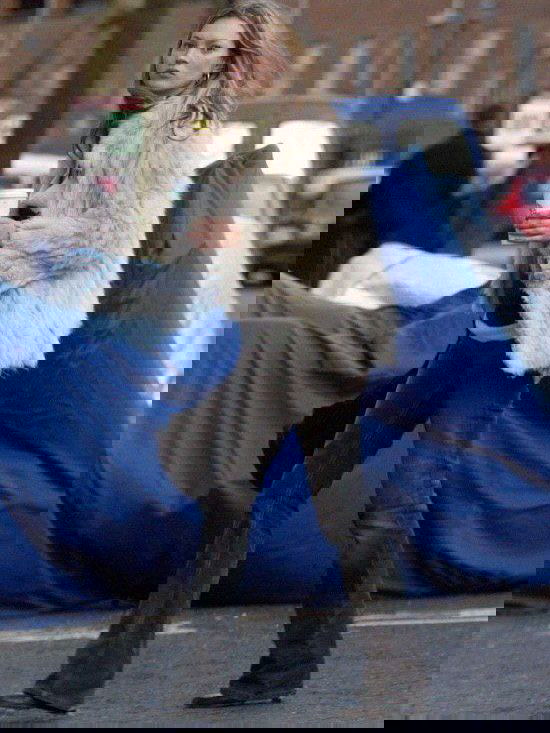 Светлая пушистая шуба и расклешённые тёмные джинсы на городской улице — сочетание фактур и силуэтов в повседневном стритстайле.