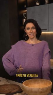Исполнительница пародии в образе Ляйсан Утяшевой в свитере у кухонного стола, кадр с подписью имени телеведущей внизу