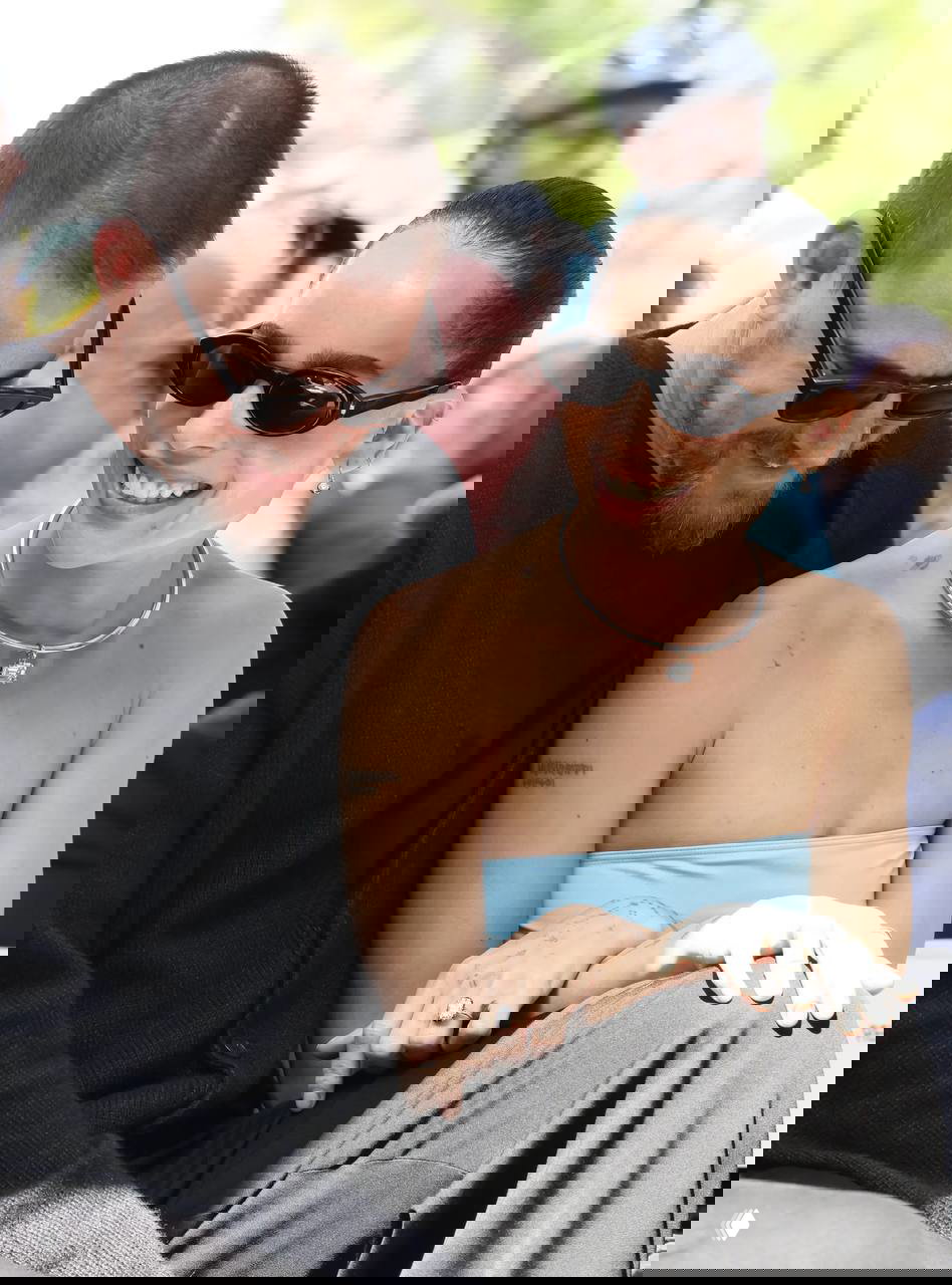 Зои Кравиц улыбается рядом с Гарри Стайлзом; они сидят вместе, на пальце Зои заметно кольцо, пара выглядит счастливой на публичном мероприятии.